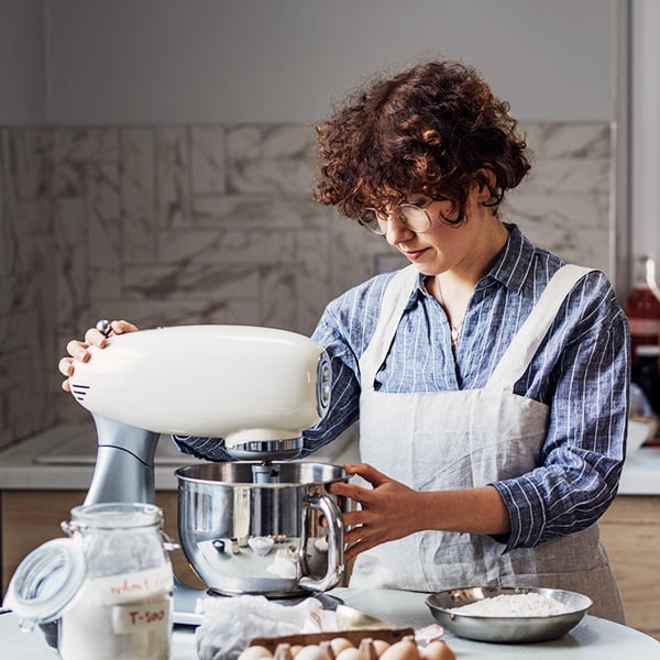 Une dame qui prpare un gteau avec un robot ptissier blanc dans sa cuisine