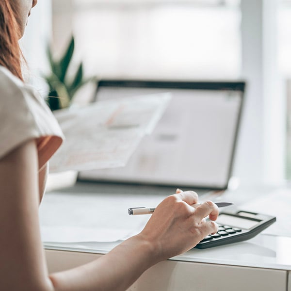 Een vrouw berekent haar energiekosten in haar bureau