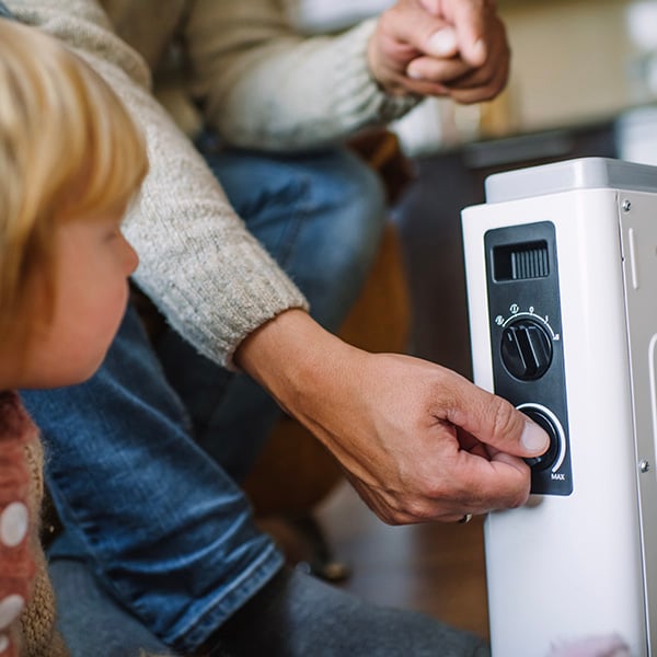 Een ouder laat zijn kind zien hoe je een bijverwarming uitzet