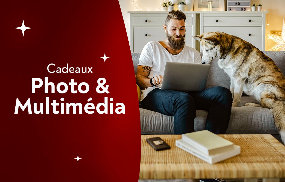 Un homme dans son salon qui regarde son pc portable avec son chien