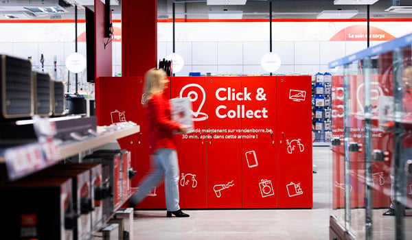 Een Vanden Borre-medewerkster brengt een keukentoestel naar de Click&Collect-kast, klaar om opgehaald te worden door de klant. 