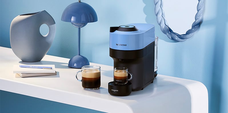 Een blauwe Nespresso koffiemachine met twee soorten koffie