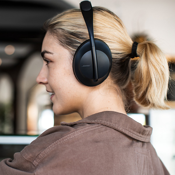 Une femme avec son casque Bose Headphones 700 