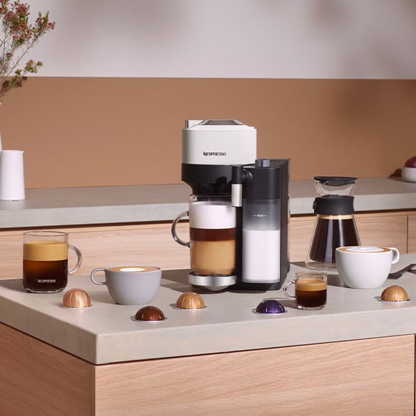 Een Nespresso Vertuo Lattissima omringd door verschillende koffiesoorten die een cappuccino maakt