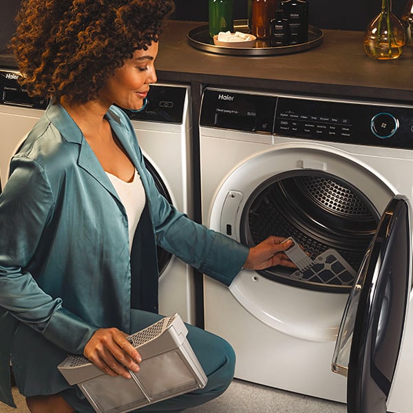 Une femme qui sort le filtre de son sche-linge