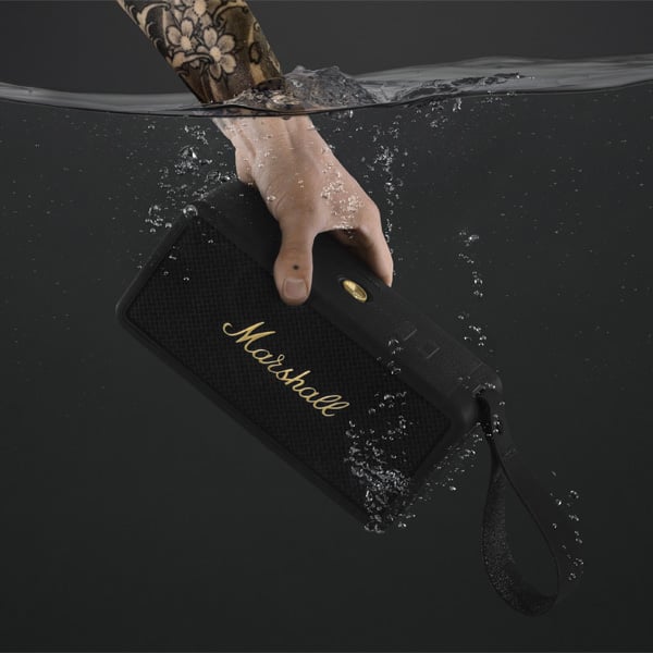 Een hand dompelt de Marshall Middleton speaker onder water