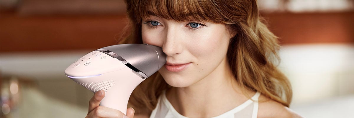 Une femme utilise l'appareil IPL Philips Lumea pour piler ses aisselles